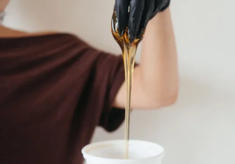 Ariel Lowell pulling sugar out of the sugar jar when discussing how often should you get sugared at bloom sugaring in ocean park santa monica